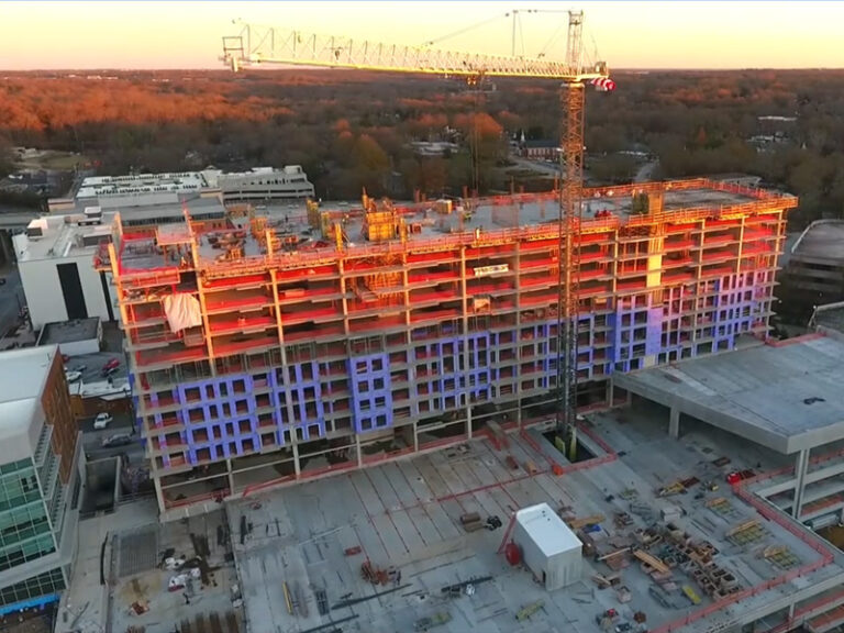 Construction site of luxury apartments at dusk, with a large crane overhead in Camperdown.
