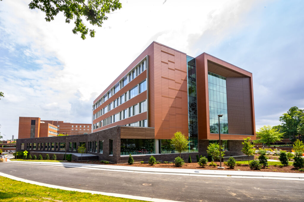 Modern multi-story office building with large windows and a landscaped entrance.