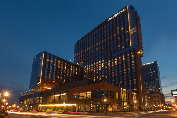 A modern hotel building illuminated at twilight with city lights and a clear evening sky, showcasing high-quality prefabrication design.