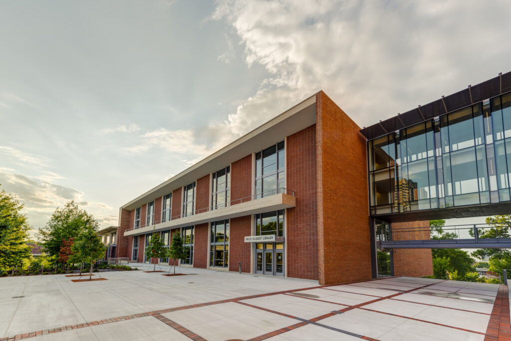Modern brick building with large windows under a cloudy sky, featuring Vondace Contracting Projects.