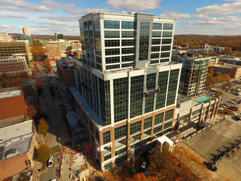 Aerial view of the modern multi-story Falls Tower with a glass facade on a sunny day in Camperdown, showcasing the surrounding urban landscape.
