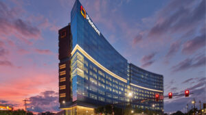 Modern corporate building illuminated at dusk with a clear company logo on the facade.