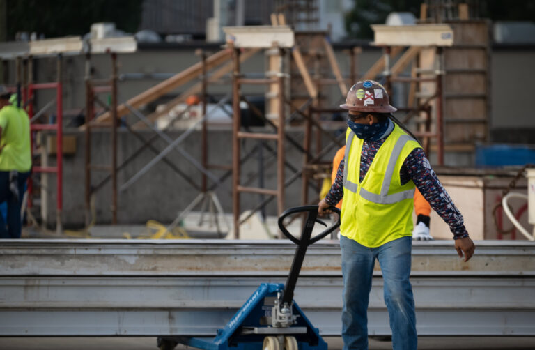 Construction worker maneuvering equipment at a Mississippi building site.
