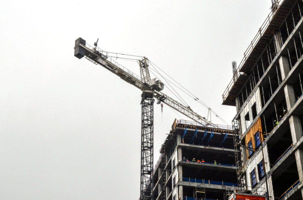 Construction site of the 760 Ralph McGill Office Tower with tower crane and partially built structure against a cloudy sky, managed by Vondace Contracting.