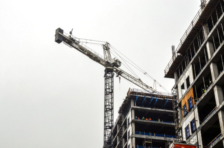 Construction site of the 760 Ralph McGill Office Tower with tower crane and partially built structure against a cloudy sky, managed by Vondace Contracting.