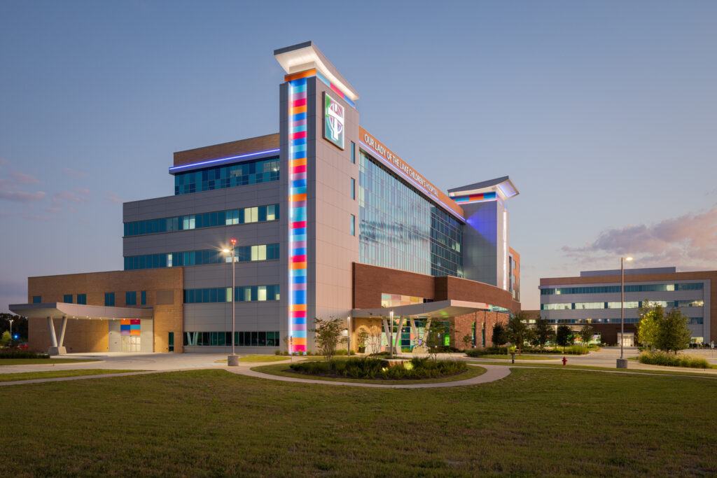 Modern hospital building illuminated at dusk with clear sky, a prestigious project by Vondace Contracting recognized at the National Awards by Associated Builders and Contractors.