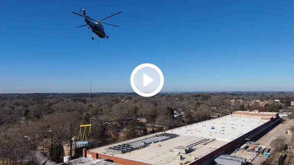 A Helolift flying over an urban landscape with a clear sky in the background.