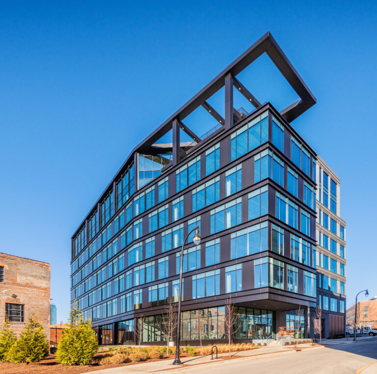Modern office building, Roxboro at Venable Center, with a distinctive angled roof feature under a clear blue sky completes construction by Vondace Contracting.