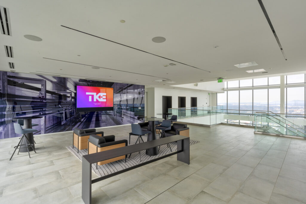 Modern corporate lobby with seating area and digital screen displaying the "Four Projects ENR" logo, honoring Projects.
