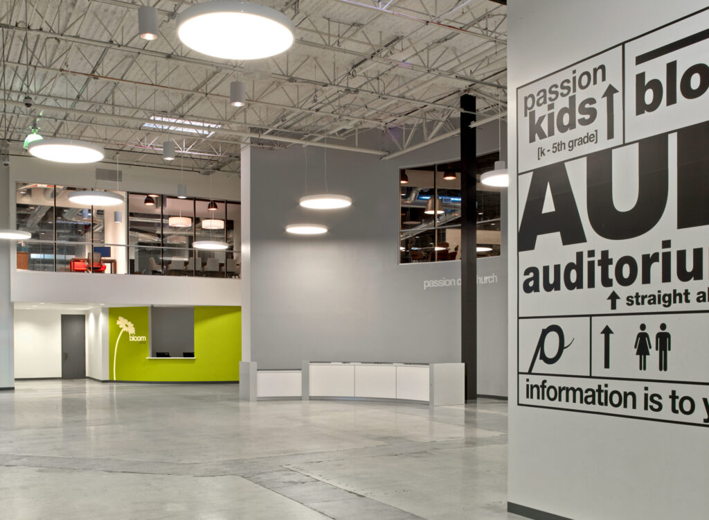 Modern lobby area with directional signs and minimalistic design, showcasing opportunities for developers.