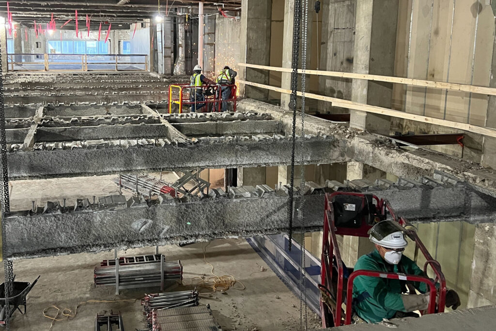 Construction workers engaging in reinforcement work at a multi-level building site, presenting opportunities for developers.