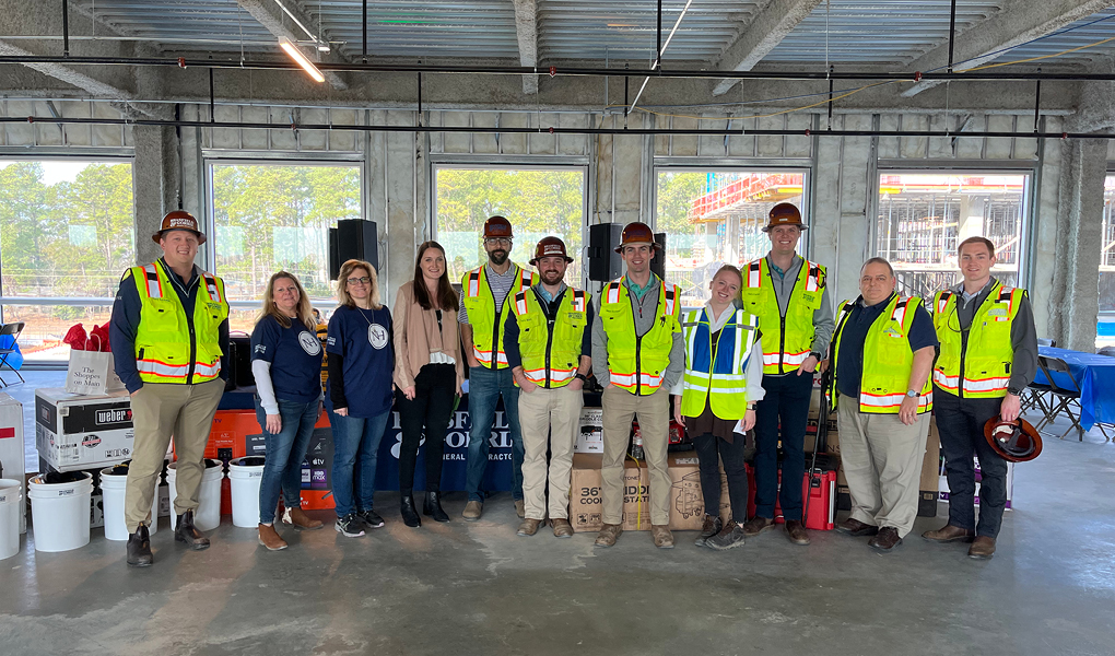 Group of construction workers and corporate employees celebrates a construction milestone together at a North Hills construction site.