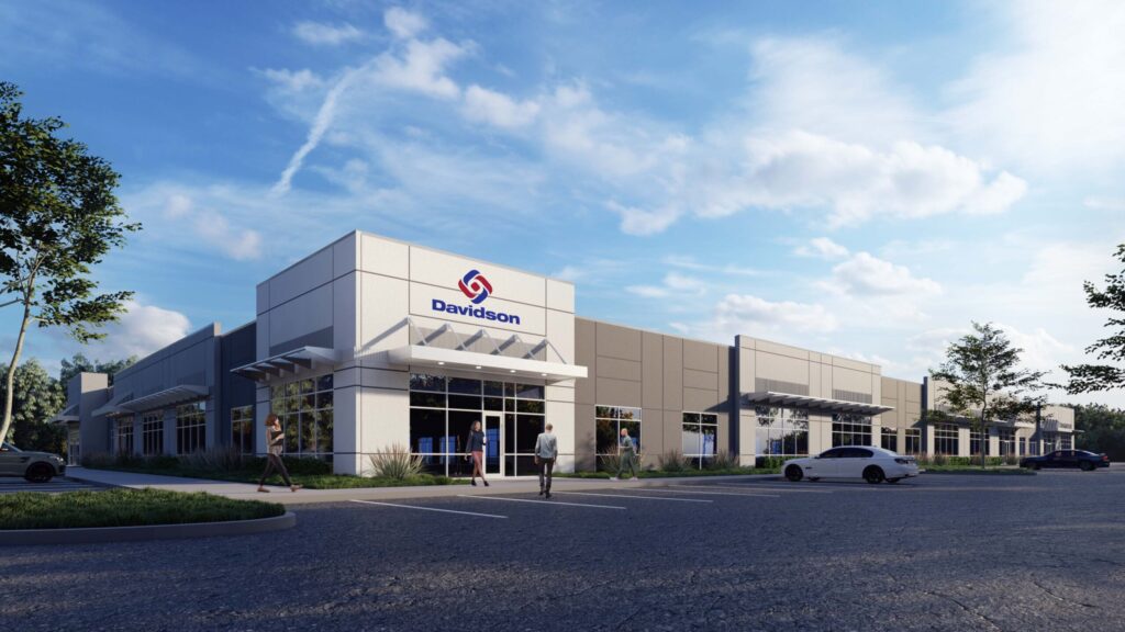 Modern commercial building with parking lot and Davidson Technologies logo under a clear sky in Huntsville.