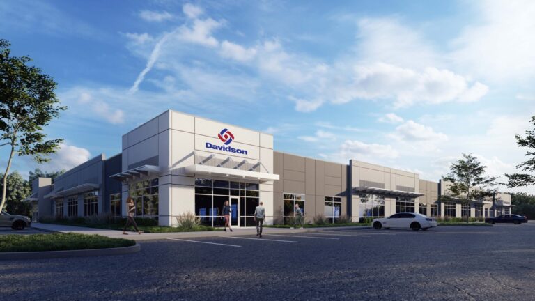 Modern commercial building with parking lot and Davidson Technologies logo under a clear sky in Huntsville.