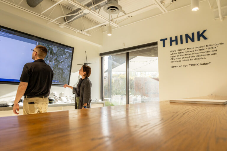 Two individuals interacting with an interactive exhibit at a technology-focused display in Birmingham, Alabama.