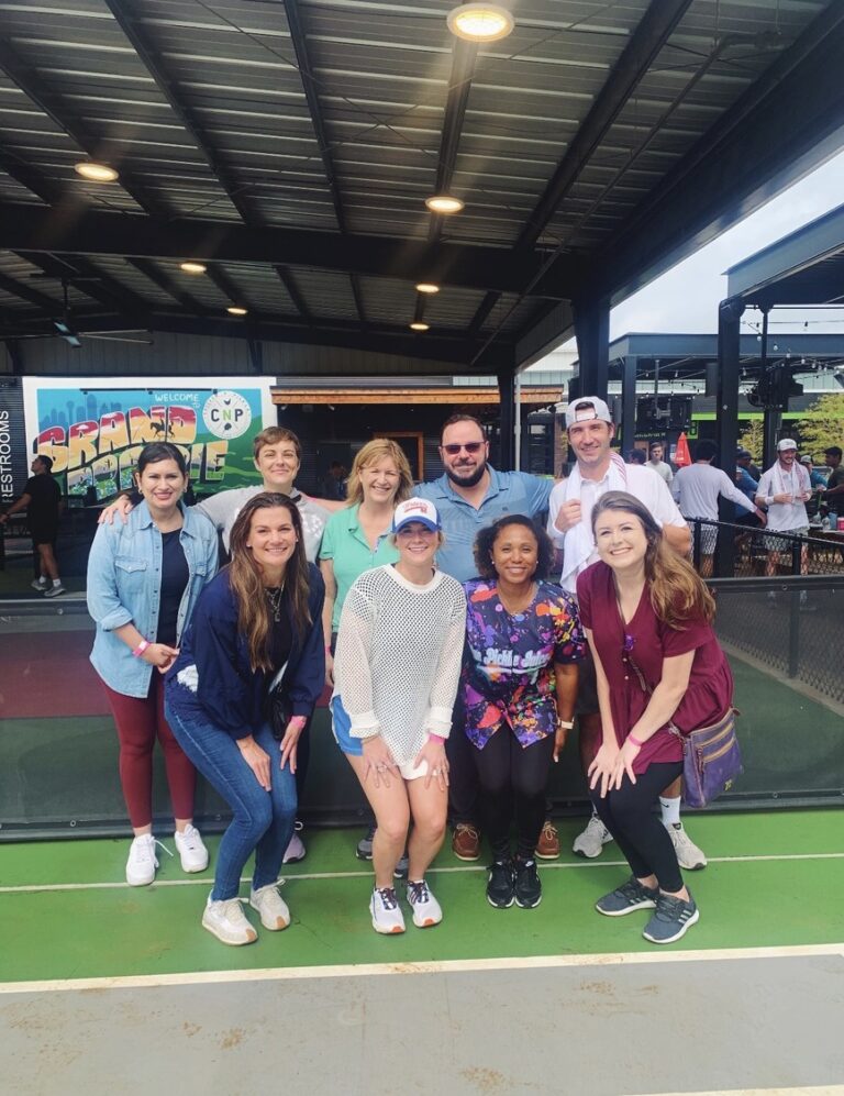 Group of people posing for a photo at an outdoor event or venue.