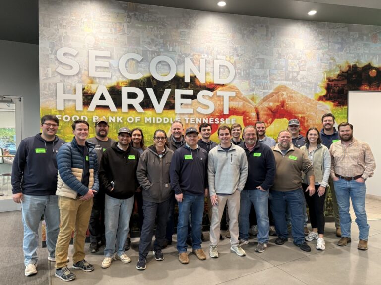 A group of people stands in front of a wall with the 