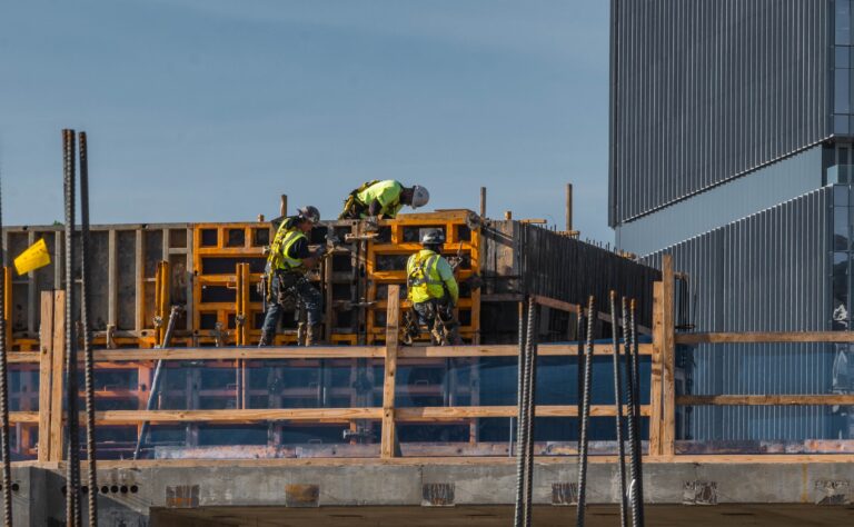 Construction workers and apprentices in field apprenticeships assembling formwork at a building site.