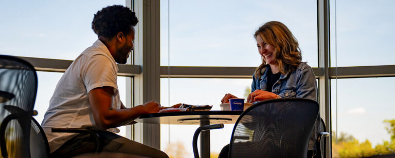 Two people sitting at a table in Orlando, Florida, and smiling during a conversation.