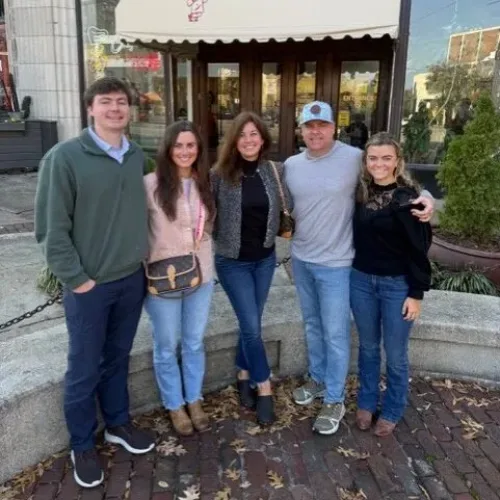 Five people, including Todd Jackson, stand closely together and smile in front of The Original Pancake House entrance on a sunny day.