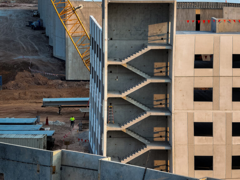 Construction site with exposed concrete staircases on a partly completed building.